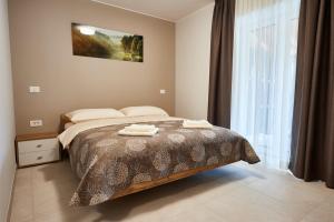 a bedroom with a bed with two towels on it at Posestvo Rouna - winery and apartments in Vipava