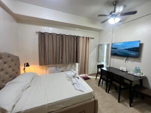 Iloilo Staycation with a Pool, Gym and Playroom في إيلويلو سيتي: غرفة نوم بسرير ومكتب وطاولة