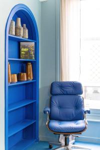 a blue chair sitting in a room with a shelf at Emblematic apartment 2BR6P Saint honoré Rivoli in Paris
