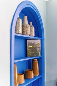 a blue book shelf with bowls and vases on it at Emblematic apartment 2BR6P Saint honoré Rivoli in Paris