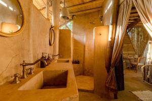 un baño con lavabo y espejo en Bamboo Tree House romantic & luxury retreat, en Brisas de Zicatela 128 fotos más
