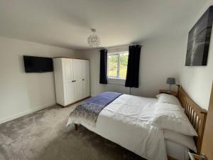 a bedroom with a large bed and a window at The Lambing Lodge in Swanton Morley