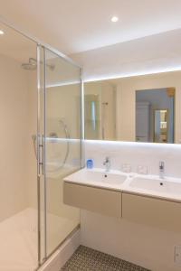 a bathroom with two sinks and a shower at Hotel les Armoiries in Valbonne