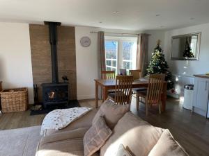 a living room with a couch and a christmas tree at The Lambing Lodge in Swanton Morley