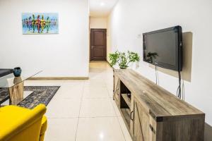 sala de estar con TV de pantalla plana en la pared en 1 Bedroom Luxury Furnished Apartment in East Legon, en Accra