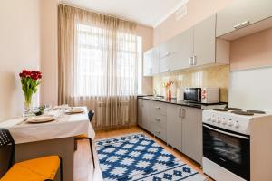 una cocina con armarios blancos y una mesa con mantel en В спокойном районе в центре города - 2 комнатная en Almaty