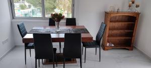 a dining room table with chairs and a vase with flowers at Ellas Modern Duplex City Center in Nicosia +11 photos