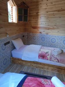 Habitación con 2 camas en una cabaña de madera en Dar Marwa, en Ouzoud