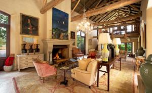 a living room with a fireplace and a table and chairs at La Residence in Franschhoek