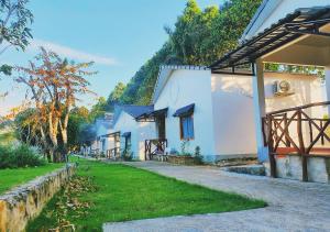 a row of white houses with a grass yard at Bungalow VinaHouse in Phu Quoc