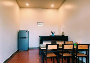 a dining room with a table and chairs and a refrigerator at Bungalow VinaHouse in Phú Quốc