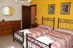 a bedroom with two beds and a table and a mirror at Casa nel Delta del Po in Scardovari