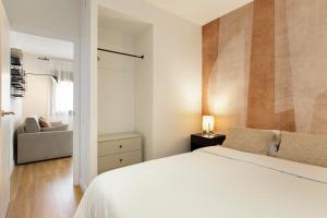 a bedroom with a white bed and a couch at Urban Chill Apartments by Olala Homes in Hospitalet de Llobregat +109 photos
