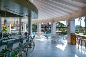 a restaurant with a bar with chairs and tables at GolfCourse Tropical Guest House Private Pool in Tierra del Sol in Palm-Eagle Beach