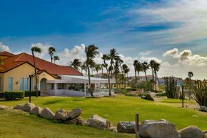 uma casa com palmeiras em frente em GolfCourse Tropical Guest House Private Pool in Tierra del Sol em Palm-Eagle Beach