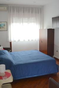 Un dormitorio con una cama azul y una ventana en Casa D'Amato Salerno, en Salerno