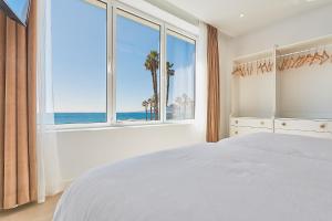 um quarto com uma cama e uma janela com o oceano em Suite Deluxe Face Mer Apart Malaga em Málaga