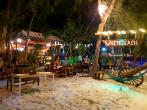 un grupo de personas sentadas en un restaurante por la noche en White Beach Bungalows, en Koh Rong