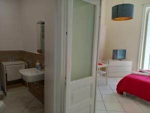 a bathroom with a door leading to a bedroom with a sink at La Casa di Elvira in Naples