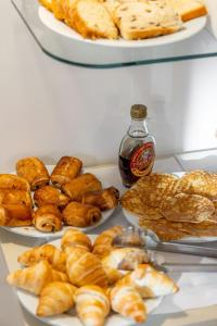 einen Tisch mit Platten aus Gebäck und Kuchen in der Unterkunft Hotel les Armoiries in Valbonne