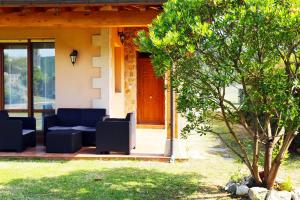 una casa con un portico con un divano e un albero di Casa Sofía a San Vicente de la Barquera