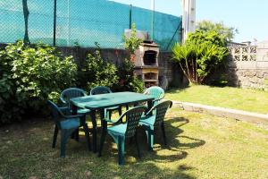 una mesa verde y sillas en un patio en Casa Sofía, en San Vicente de la Barquera