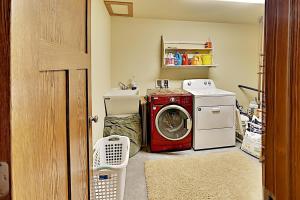 a laundry room with a washing machine and a washer at Ravensong Lodge in New Auburn