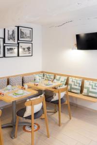 Hotel les Armoiries في فالبون: غرفة طعام مع طاولات وكراسي خشبية