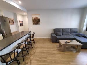 een woonkamer met een bank en een tafel bij Apartamento Alfareria de Triana - Kainga Homes in Sevilla