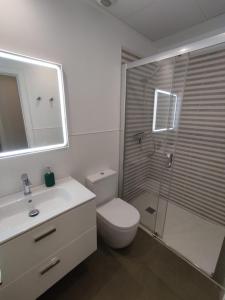een badkamer met een douche, een toilet en een wastafel bij Apartamento Alfareria de Triana - Kainga Homes in Sevilla