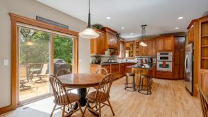 a kitchen with wooden cabinets and a table and chairs at Woodhaven Retreat in Shakopee