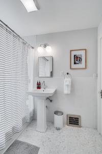 uma casa de banho branca com um lavatório e um chuveiro em Nokomis Blue em Minneapolis