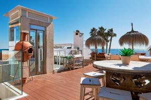 a deck with a table and a view of the ocean at Suite Deluxe Face Mer Apart Malaga in Málaga