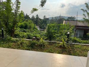 uitzicht op een tuin met planten en een huis bij Hilltop Palace Elpitiya in Elpitiya