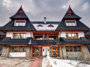 ザコパネにあるPokoje Gościnne Zbyszkoの黒屋根の大木造家屋