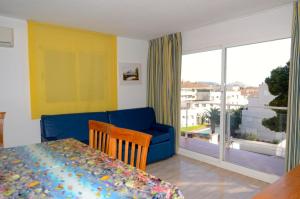 - un salon avec un canapé bleu, un lit et une fenêtre dans l'établissement Apartamento Duplex BONSOL 14, à L'Estartit