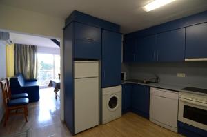 une cuisine avec des armoires bleues et un lave-linge dans l'établissement Apartamento Duplex BONSOL 14, à L'Estartit