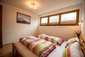two beds in a room with two windows at Haus Raggl in Landeck
