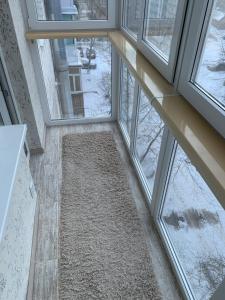 ein leerer Flur mit Fenstern in einem Gebäude in der Unterkunft Апартаменты LUXURY in Berdychiv