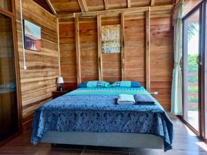 1 dormitorio con 1 cama en una pared de madera en L'Oasis Don Juan, en Don Juan