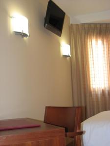 a bedroom with a desk and a bed and a television at Hotel Ruta de la Plata de Asturias in Pola de Lena