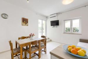 a kitchen and dining room with a table and a bowl of fruit at APARTMAN MARICA LUN, OTOK PAG in Lun