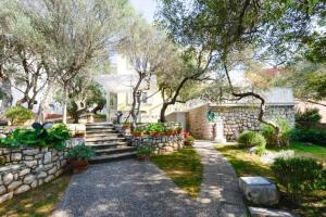 a garden with a stone wall and some plants at APARTMAN MARICA LUN, OTOK PAG in Lun