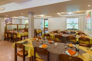 un restaurant avec tables et chaises et nappes jaunes dans l'établissement Azureva La Londe les Maures, à La Londe-les-Maures