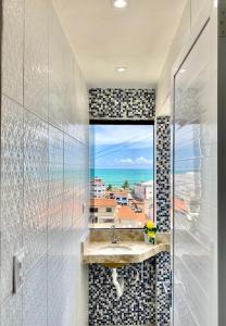 a bathroom with a sink and a view of the ocean at Pousada Maresia in Maragogi