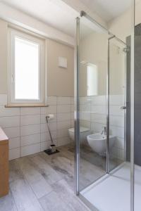 a bathroom with a glass shower stall and a sink at Appartamenti Ceccherini Rosa-Viola in Malcesine