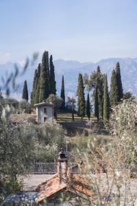 a house in a field with a fence and trees at Appartamenti Ceccherini Rosa-Viola in Malcesine