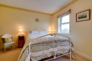 um quarto com uma cama branca e uma janela em Barley Cottage em Whittington