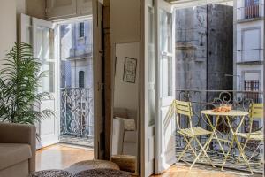 a room with a balcony with a table and chairs at Virtudes Flat w/ AC & Balcony by LovelyStay in Porto