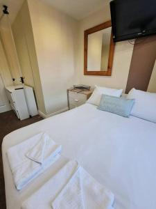 um quarto com uma cama branca e toalhas em Lovely bedroom em Londres
